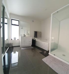 a large white bathroom with a shower and a mirror at Homestead Hideaway in Ohoka in Ohoka