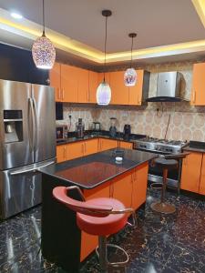 a kitchen with orange cabinets and a stainless steel refrigerator at TheGeneral Place in Ikorodu