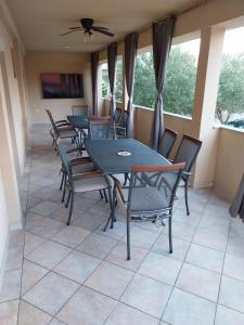 a dining room with tables and chairs and windows at Apartmani Lučić - Privlaka in Privlaka