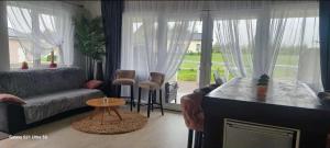 a living room with a couch and a large window at Lion Sauna in Vydmantai