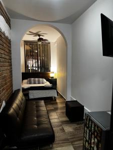 una sala de estar con un sofá y una cama en Hotel Boutique Colonial Cartago, en Cartago