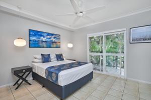 a bedroom with a bed and a large window at Coral Views at Clifton Beach in Clifton Beach
