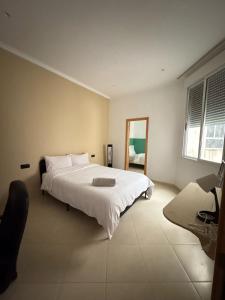 a bedroom with a large white bed and a mirror at Nul in Tetouan