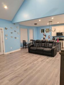 a living room with a black couch and a kitchen at Work and play close to everything in Frederick