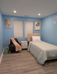 a bedroom with blue walls and a bed and a chair at Work and play close to everything in Frederick