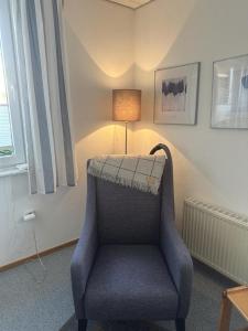 una sedia blu in una stanza con lampada di Ferienhäuschen Seekrabbe a Baltrum