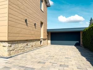 a building with a garage door and a driveway at WILD&COZY Ferienhaus mit 160m2, Garage und 2 Bäder in Blankenburg