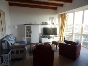 un soggiorno con divani e TV a schermo piatto di Ankerplatz im Strandschlösschen a Baltrum