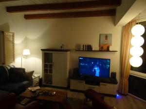 un soggiorno con TV e divano di Ankerplatz im Strandschlösschen a Baltrum