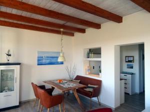 una cucina e una sala da pranzo con tavolo e sedie di Ankerplatz im Strandschlösschen a Baltrum