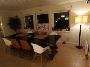 a dining room with a table and chairs and a lamp at Skap Opplevelser in Svingvoll