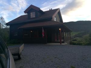 a house with a flag in front of it at Skap Opplevelser in Svingvoll