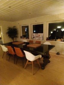 a dining room with a black table and chairs at Skap Opplevelser in Svingvoll
