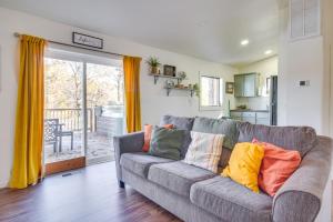 a living room with a gray couch with colorful pillows at Deck and Boat Dock Lakefront Cabin in Eucha! in Eucha