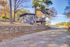a house with a stone wall next to a road at Deck and Boat Dock Lakefront Cabin in Eucha! in Eucha