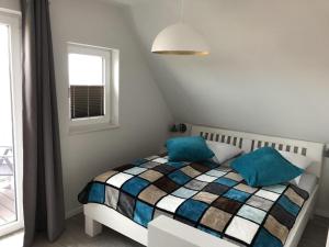 巴尔特鲁姆Westhook Appartement 3的一间卧室，配有一张带蓝色枕头的床和一扇窗户