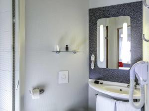 a bathroom with a sink and a mirror at ibis Orange Sud in Orange