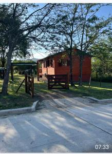 eine Hütte mit einem Picknicktisch vor einem Baum in der Unterkunft Cabaña turistica para huespedes! in La Falda + 9 Fotos