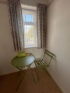 a green table and a chair in a room with a window at Gravesend in Gravesend +11 photos