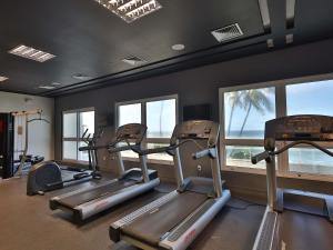 a gym with several tread machines and windows at Mercure Salvador Rio Vermelho in Salvador