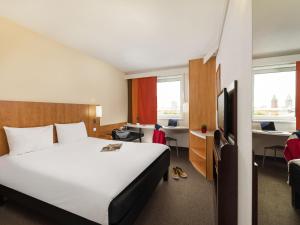 a hotel room with a large bed and a desk at Ibis Praha Mala Strana in Prague +36 photos
