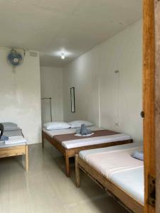 a room with two beds and two tables in it at RedDot Guest House in General Luna