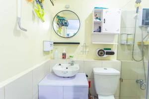 een badkamer met een wastafel, een toilet en een spiegel bij Cheapest Staycation at the Metro in Manilla +1 foto