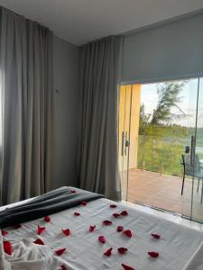 a bedroom with a bed with red roses on it at Villa brisa icaraizinho suíte premium 1 andar in Amontada +12 photos