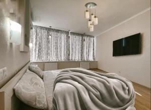 a bedroom with a bed with a blanket on it at Мост сити АПП 75 in Dnipro