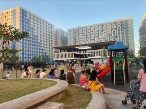 een groep mensen in een park met een speeltuin bij Cheapest Staycation at the Metro in Manilla