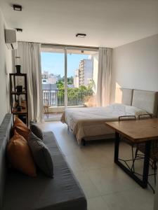 a bedroom with a bed and a table and a window at Departamento Estudio Deluxe in La Plata