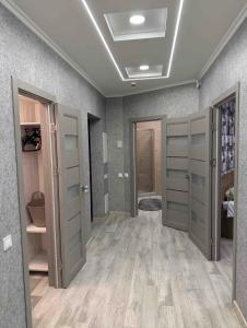 a room with gray doors and wooden floors at Delux Apartment Dmytro in Ternopilʼ