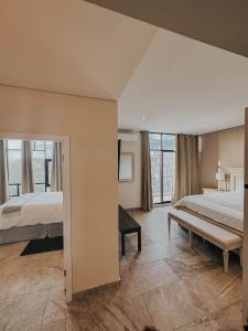 a large bedroom with two beds and a large window at Suites Lassa in Ensenada