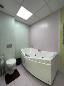 a white bathroom with a tub and a toilet at Мост сити АПП 52 Джакузи in Dnipro +36 photos