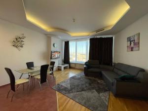 a living room with a couch and a table at Мост сити АПП 52 Джакузи in Dnipro