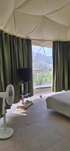 une chambre avec un lit, une télévision et une fenêtre dans l'établissement Romantic Dome Escape in Saint-Martin, à Saint-Martin