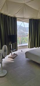 une chambre avec un lit et une grande fenêtre dans l'établissement Romantic Dome Escape in Saint-Martin, à Saint-Martin