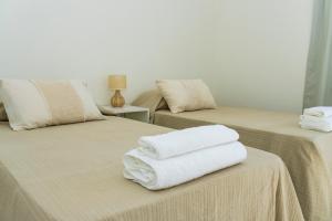 zwei Betten mit Handtüchern drauf in der Unterkunft Refugio Vertientes in Cafayate