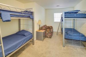 a bedroom with two bunk beds and a chair at Lyles Peaceful Creekside Home Hot Tub and Fire Pit in Lyles