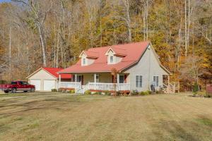 a house with a red roof on a yard at Lyles Peaceful Creekside Home Hot Tub and Fire Pit in Lyles