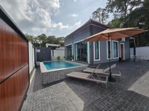 una casa con piscina y sombrilla en TiTIME POOL VILLA, en Ao Nang 