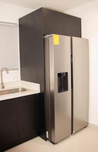 un réfrigérateur en acier inoxydable dans une cuisine avec un évier dans l'établissement Casa PAMPA, à Liberia