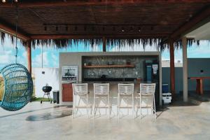 a group of white chairs sitting in a bar at Casa Vista Mar, Piscina Aquecida/Hidro, Cozinheira in Barra do Camaragibe