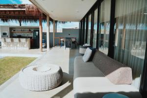 a living room with a couch and a table at Casa Vista Mar, Piscina Aquecida/Hidro, Cozinheira in Barra do Camaragibe