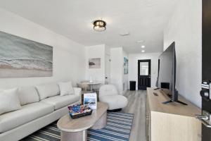 een woonkamer met een witte bank en een tafel bij Boardwalk John's Pass in St Pete Beach