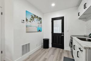 een keuken met een zwarte deur en een wastafel bij Boardwalk John's Pass in St Pete Beach