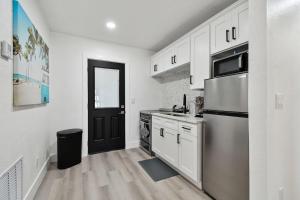 een keuken met witte kasten en een zwarte deur bij Boardwalk John's Pass in St Pete Beach