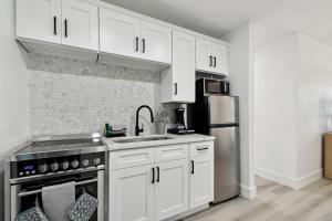 een keuken met witte kasten en een roestvrijstalen koelkast bij Boardwalk John's Pass in St Pete Beach +8 foto's