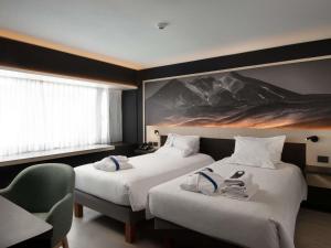 a hotel room with two beds with towels on them at Novotel Santiago Vitacura in Santiago +226 photos