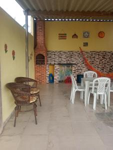 un patio avec des chaises et des tables ainsi qu'un mur en briques dans l'établissement Bella casa de praia, à Araruama